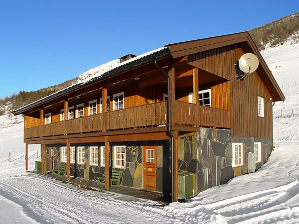 Beliggende i et snedækket landskab tilbyder denne to-etagers træhytte med en stenbund et hyggeligt tilflugtssted for din skiferie. Kabinen har en balkon, flere vinduer og en parabol. Dens klare blå himmel viser de snedækkede skråninger af maleriske Wagrain.